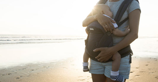 Woman holding her baby on the beach
